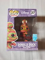 Front view of the boxed Funko Pop Art Series Donald Duck figure, showing colorful patterned design, Disney and Funko branding, and number 27.