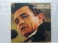 Front cover of Johnny Cash At Folsom Prison vinyl record showing close-up portrait of Cash, with wear and aging visible.