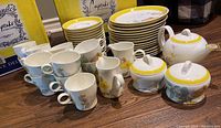 Overall set arranged showing teapot, sugar bowl, cups, saucers, plates in spring tulip pattern