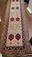 Full view of the Turkish wool blend runner rug laid on hardwood floor showing geometric multi-colored patterns and border.