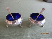 Pair of sterling silver master salts each with cobalt blue glass liner and a sterling spoon inside.
