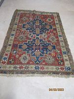 Full view of the antique Kazakh rug laid flat, showing overall design and colors.