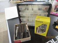 Photo showing black plastic organizer with transparent drawers, boxed Doweling Jig, and Heli-Coil Thread Repair Kit on table.