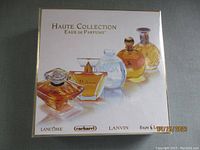 Front image of the Haute Collection Eaux de Parfums boxed set showing five perfume bottles illustration.