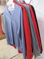 Blue V-neck sweater and various shirts on a rack