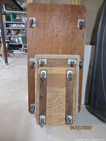 Underside view of all three wooden dollies showing the swivel caster wheels attached to each.