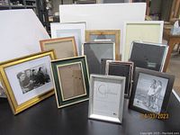 Overview of eleven varied photo frames in multiple styles and sizes arranged on a table.