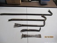 Full set of demolition and carpentry pry tools laid out on table showing all five items.