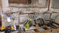 Overall view of five bins filled with assorted plumbing supplies and hardware alongside several power tools on top