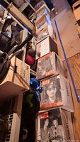 Three cardboard boxes of Life magazines stacked on floor among storage items