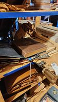 Wooden shelving unit holding stamp albums, printer and newspaper ephemera