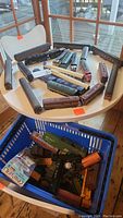 Tabletop view of multiple HO gauge locomotives and passenger cars in mixed liveries