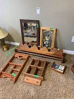 Wide view of all items grouped on carpet showing mirror, stained glass panel, shelves, tray and coasters