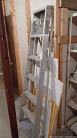 Full view of the 6 ft aluminum stepladder standing upright in basement, showing its height, step size, and folding supports.