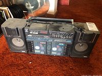 Front view of Pulser boom box with dual speakers and two cassette compartments showing wear and dust.