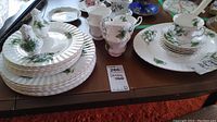 Overall view: stacked dinner plates, salad plates, teacups and saucers on table