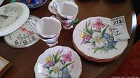 Four salad/dessert plates stacked, same floral design as cups and saucers.