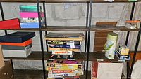 Shelf view showing various boxed board games, mostly vintage with some wear