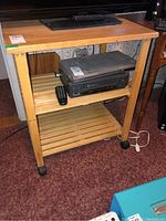 Front view of wooden cart with items placed on shelves to show scale and structure.