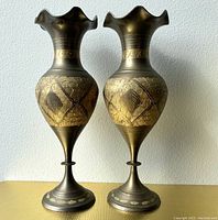 Pair of vintage brass ruffle top vases, front view showing etched gold-tone leaf and textured designs on belly and base.