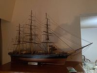 Full view of the Cutty Sark model ship showing the hull, masts, and rigging on a stand.