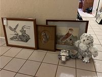 Three framed owl art prints along with two plush owls and a ceramic cup arranged on floor for clear view of lot contents.