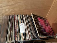 Top-down view of a stack of vinyl records showing multiple album covers including April Wine and Fleetwood Mac.