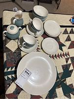 Full collection of Royal Doulton Vista china including cups, saucers, plates, teapot, and creamer arranged on a quilted surface.