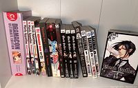 Shelf showing manga volumes from Dramacon Ultimate Edition omnibus, Manly Appetites volumes 1-3, Romeo + Juliet omnibus, Paradise Kiss, March Story, Black Butler boxed set, and Bakuman volumes 1-3. All appear in good condition with colorful covers.