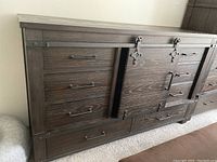 Left side view of the wood hutch showing drawers and metal sliding barn door hardware.