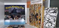 Full view of the sealed Nuns Having Fun calendar, Charley Harper Isle Royale 1000 piece puzzle, and Dragonball Super black and white ink print