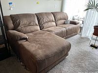 Full view of the brown electric reclining sectional sofa with chaise lounge, showing overall shape and fabric texture.