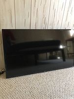 Front view of the TCL 40-inch flat screen TV turned off, showing black screen and bezel.