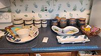 Kitchen counter with ceramic canisters, ceramic platters, napkins, and basket of magnets arranged for view.