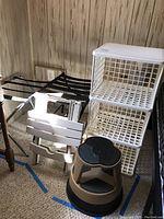 Image shows all items including pair of luggage stands, plastic cubby shelf, rolling step stool, and folding plastic table in one view.