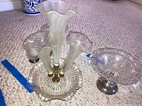 Four pieces of sterling weighted art glass displayed on carpet including three fluted vases mounted on a round base and one pedestal cookie dish.