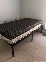 Twin bed frame with mattress on top showing overall frame and support