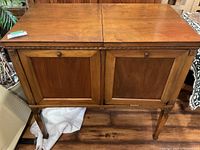 Front view of Columbia Grafonola wooden cabinet showing paneled doors and legs