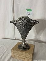 Front view showing the wide flat fan shape with detailed floral and scrollwork patterns in silver plate.