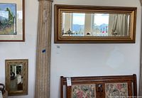 Wide angle showing the full large rectangular mirror on the wall above furniture, illustrating size and context.