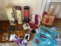 Full lot overview showing all wine carriers, switch plates, flag, makeup bag and decorative items on floor against wall.