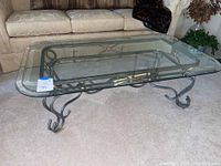 Top-down view of rectangular glass top with black and gold metal base coffee table in living room