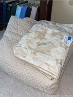 Folded queen sized comforter showing floral pattern and textured underside alongside matching pillow shams.