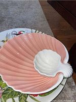 Large pink and white ceramic shell-shaped serving dish with ribbed and shell design.