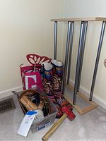 Lot contents showing floral rain boots, plastic tote with belts and gloves, wooden shoe rack, mallet, and shoe stretcher