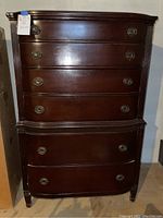 Front view of solid wood vintage dresser showing six drawers with metal handles and fluted side columns.