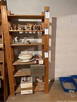 Wooden 6-shelf shelf unit against a concrete wall with various items on shelves (not included).