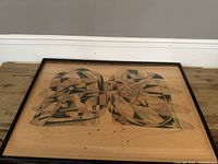 Framed abstract watercolour painting featuring geometric patterns in earth tones, depicting two stylized heads or similar forms.
