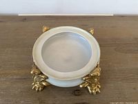 Overhead view of white ceramic centerpiece pot showing interior and four gold gilt claw feet
