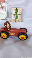 Wooden Curious George car with figure on top